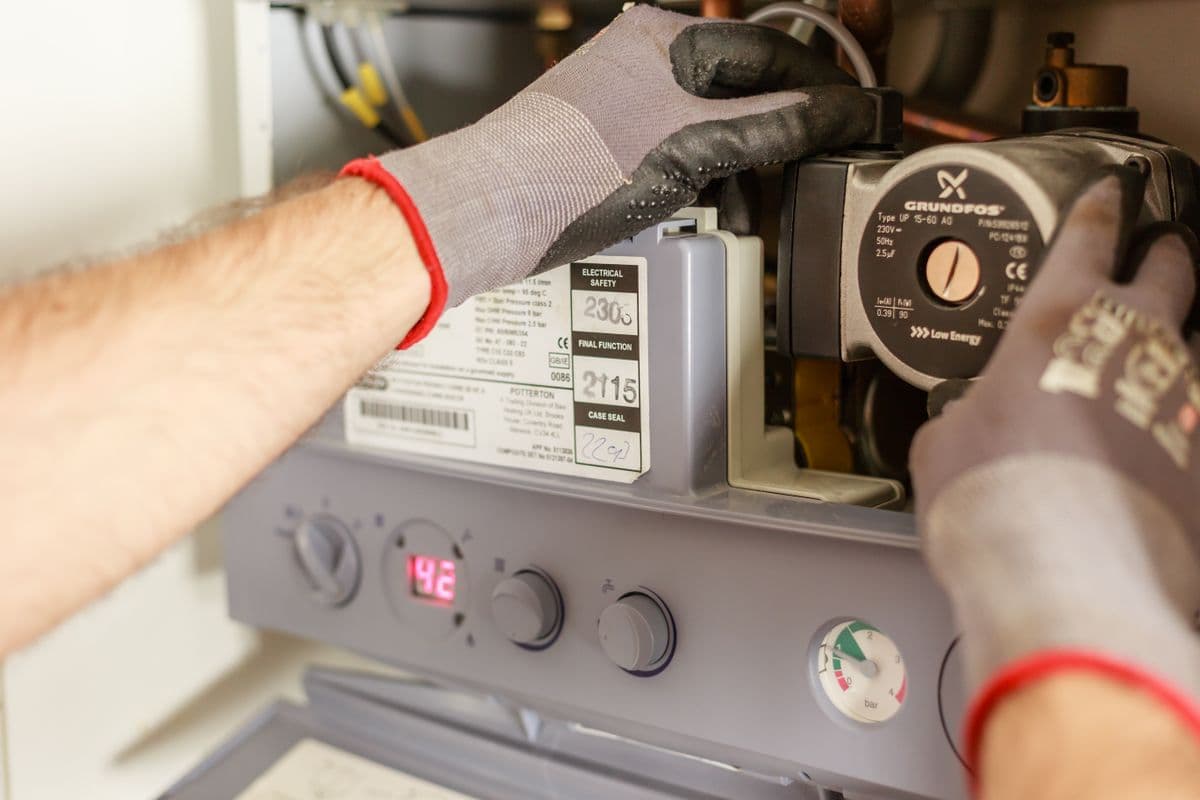 Boiler stopped working — engineer checking the pressure gauge and display panel on a combi boiler