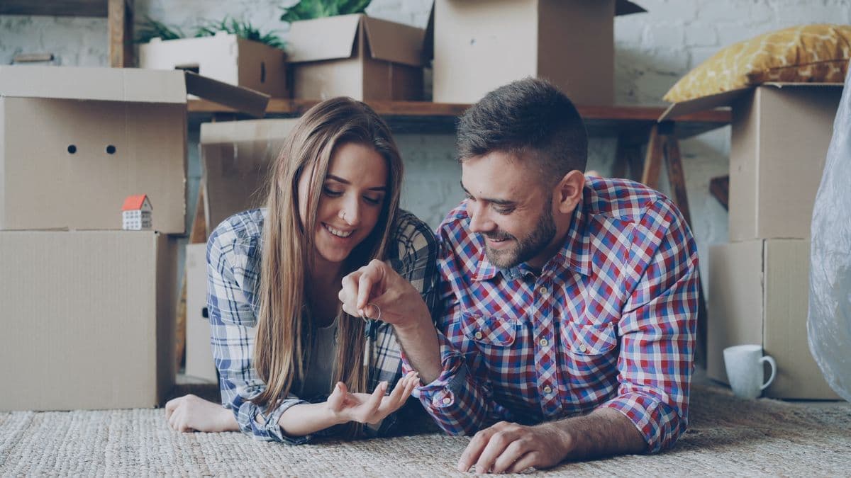 Couple moving in together with boxes — the admin checklist covers council tax, insurance, utilities, and household records