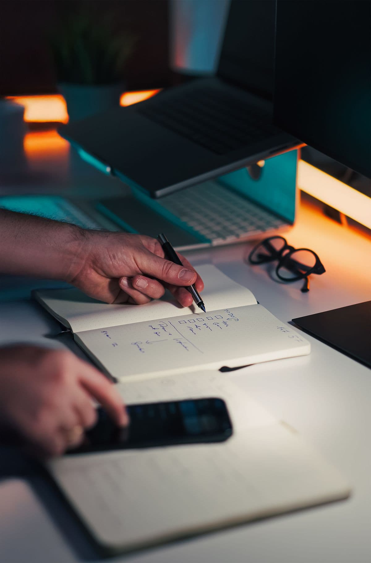 Person with notebook and laptop organising home admin — the kind of task a dedicated productivity app handles better than a notebook