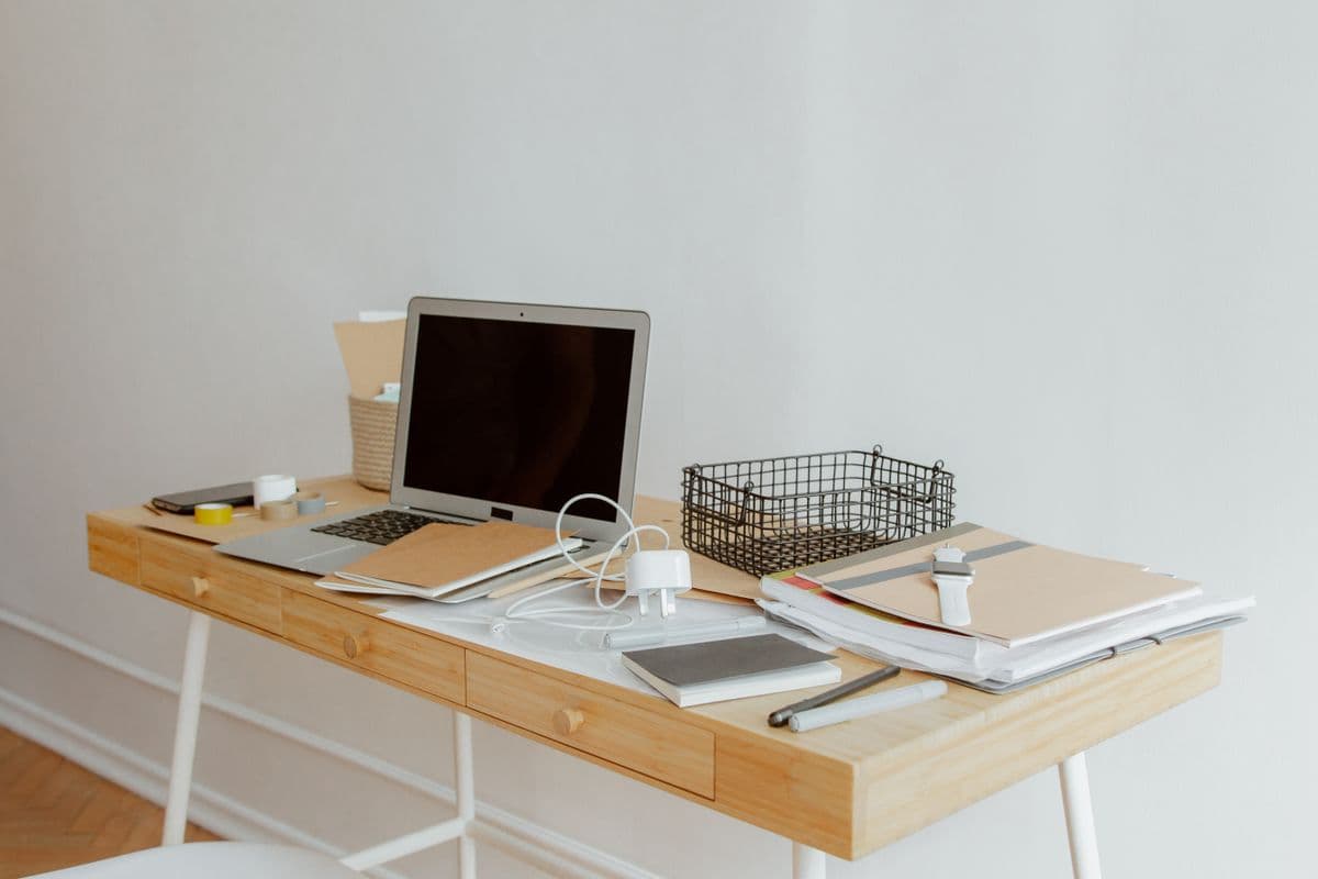Organised desk with notebook and laptop — choosing the best productivity app for home life requires different criteria than work apps